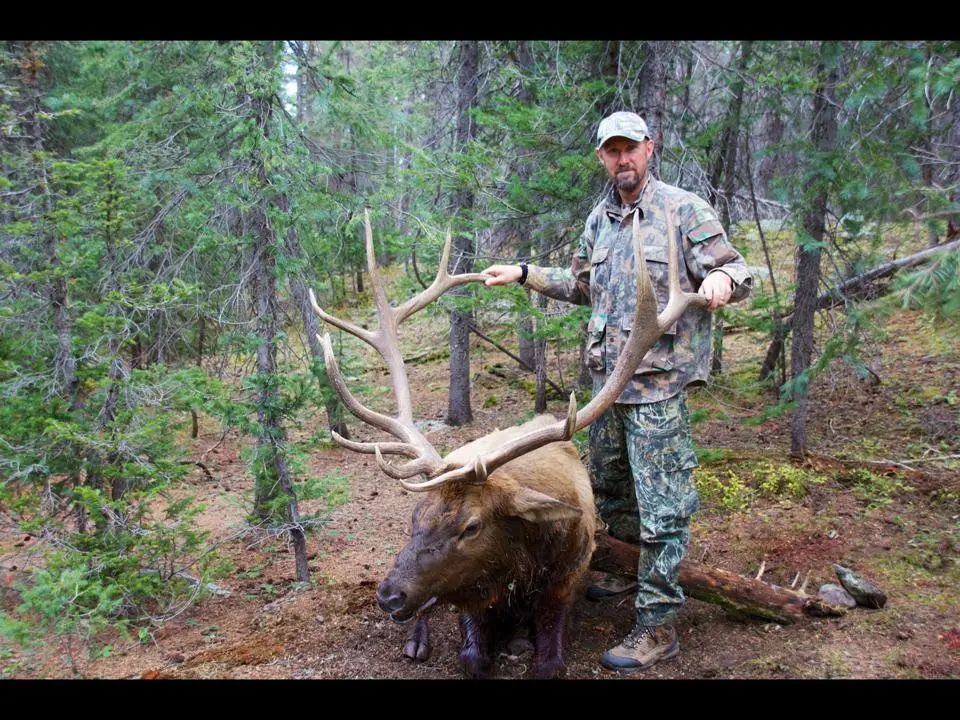 Hunter holding the antlers of the elk he hunted