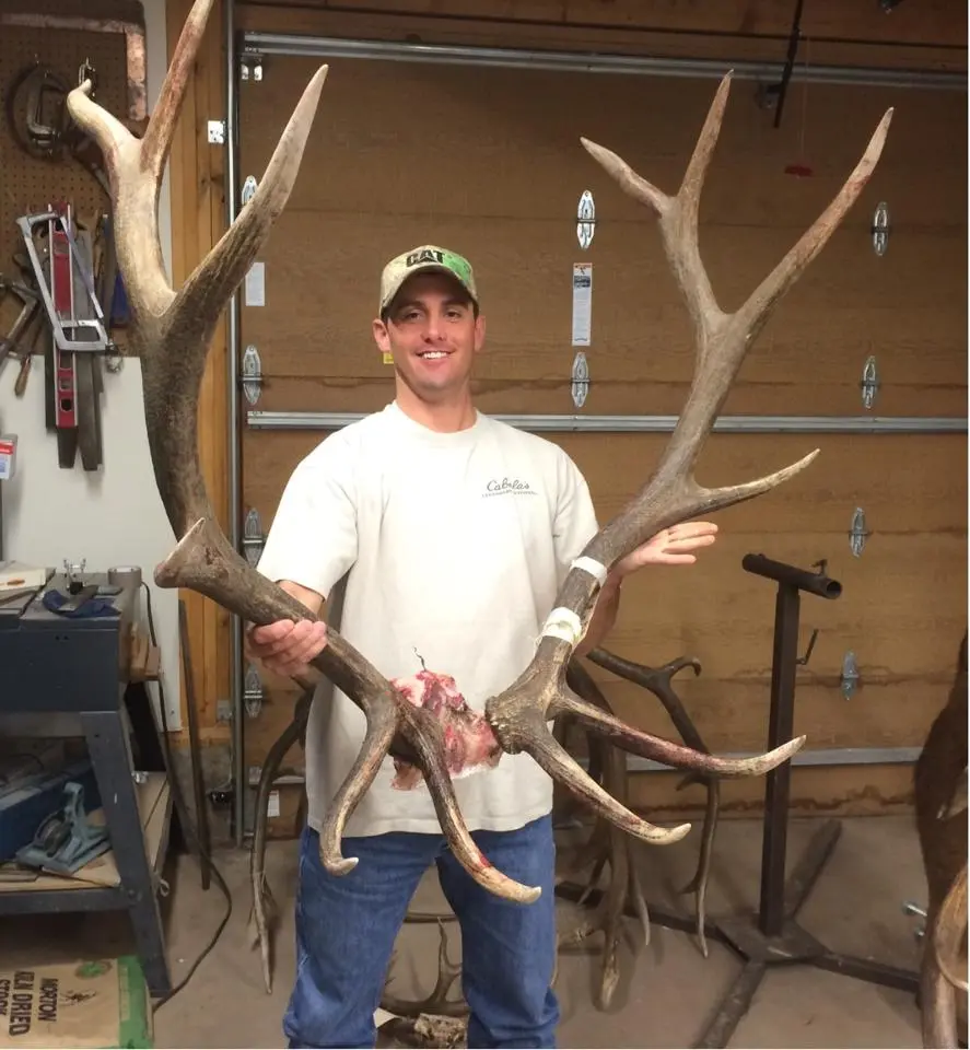 Hunter holding large elk antlers