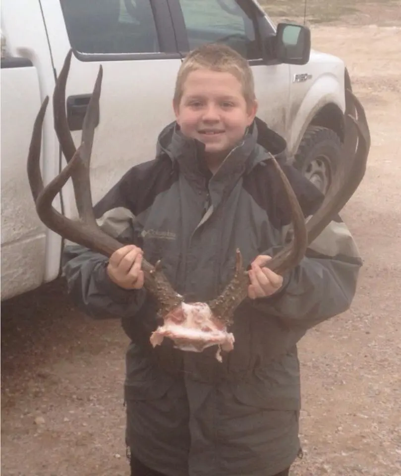 Young boy holding deer antlers